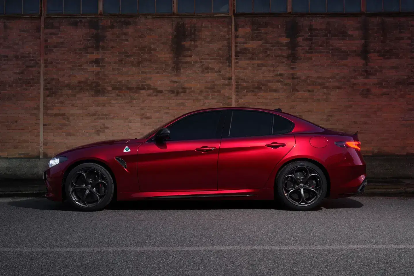 2024 Alfa Romeo Giulia Collezione side profile view highlighting exclusive Rosso Collezione paint and Quadrifoglio clover badge
