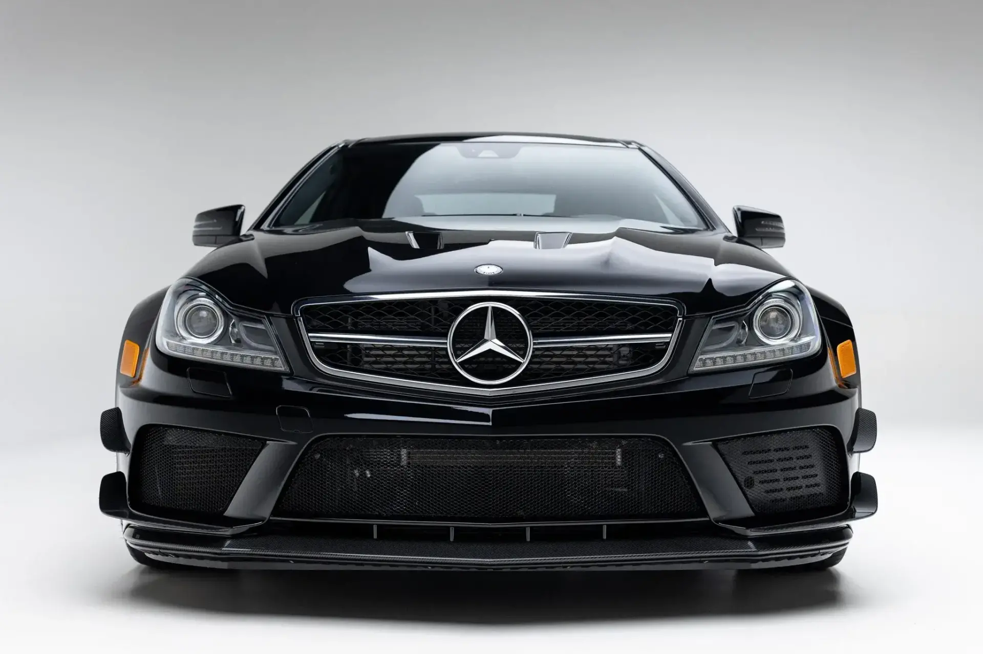 2012 Mercedes-Benz C63 AMG Black Series front three-quarter view showcasing widened fender flares and vented hood design