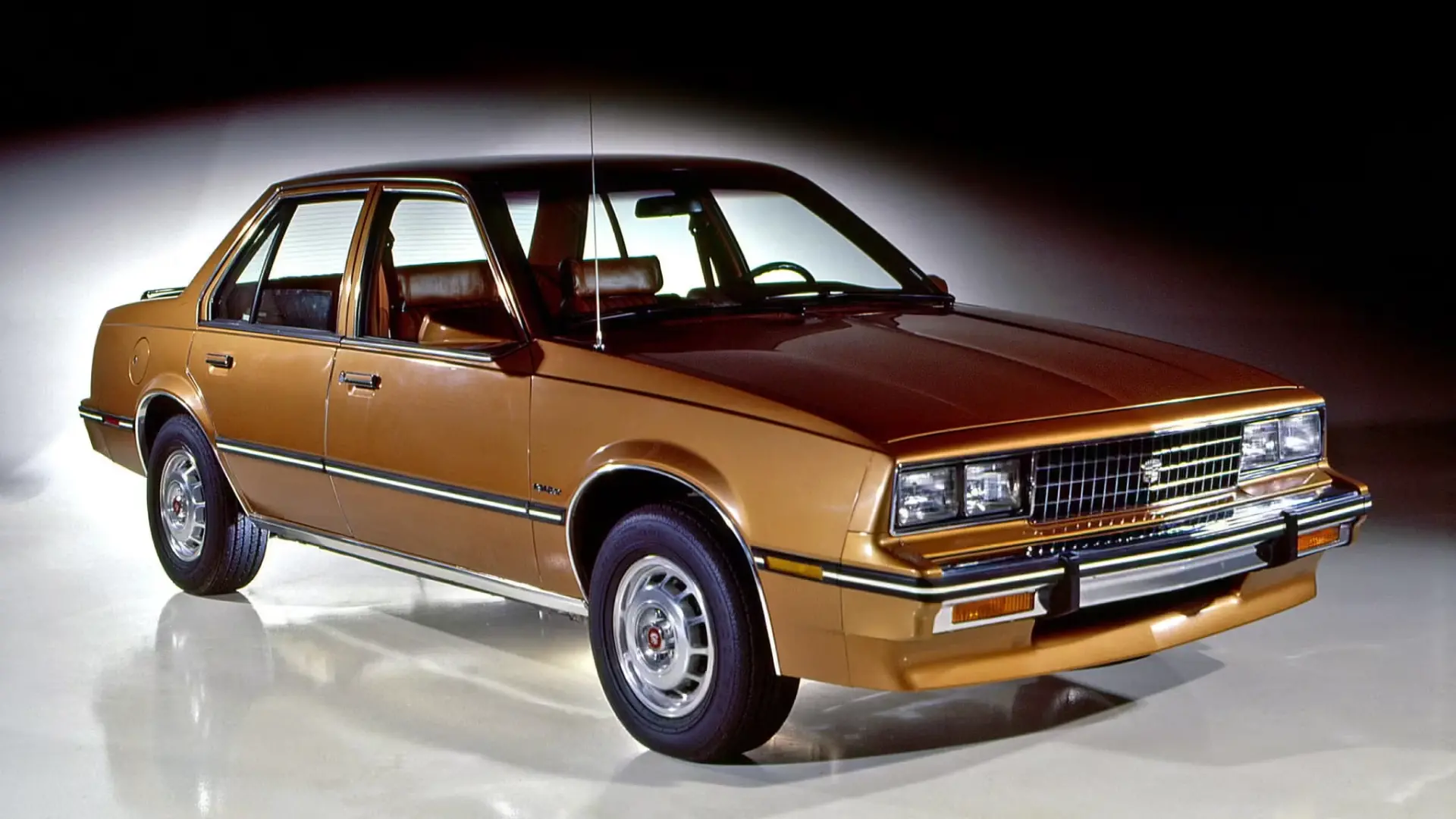 1985 Cadillac Cimarron compact sedan in burgundy showing rebadged GM J-body platform with formal grille