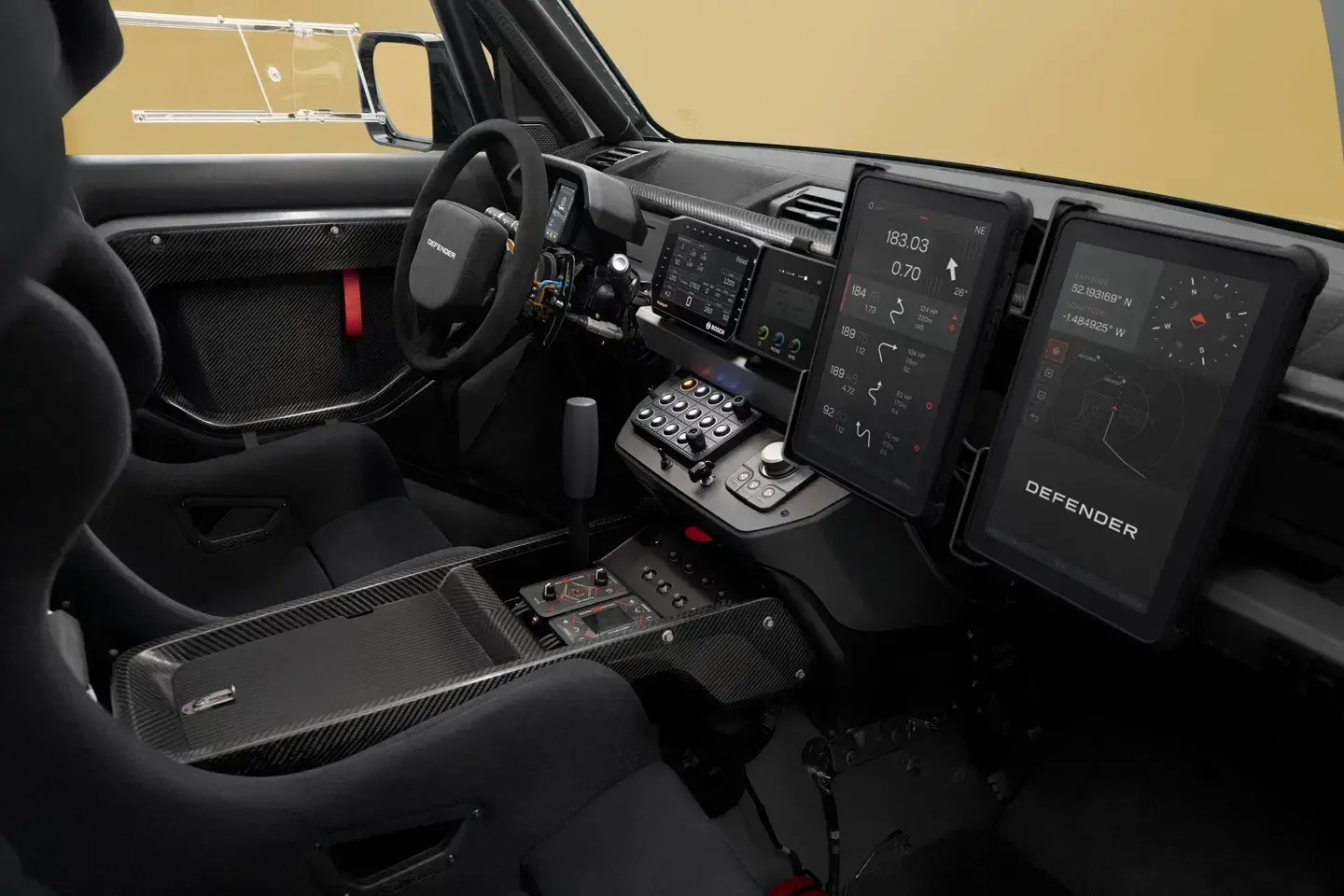 2026 Land Rover Defender D7X-R interior showing FIA roll cage dual navigation tablets and rally instrumentation