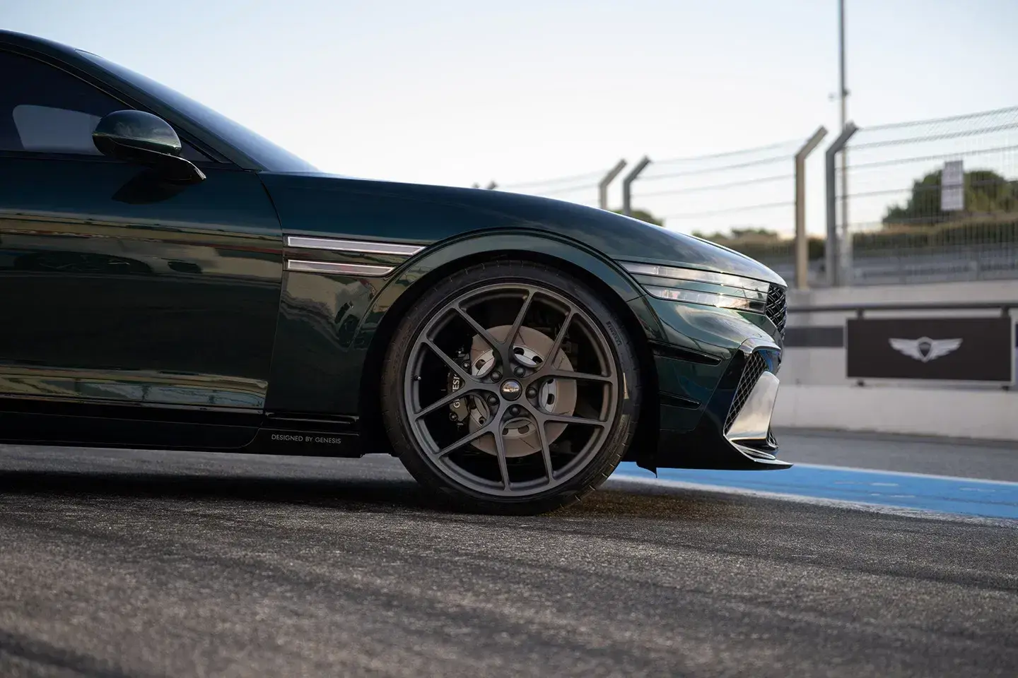 Genesis G90 Wingback Concept rear three-quarter view highlighting twin spoilers and quad exhaust outlets in striking green finish