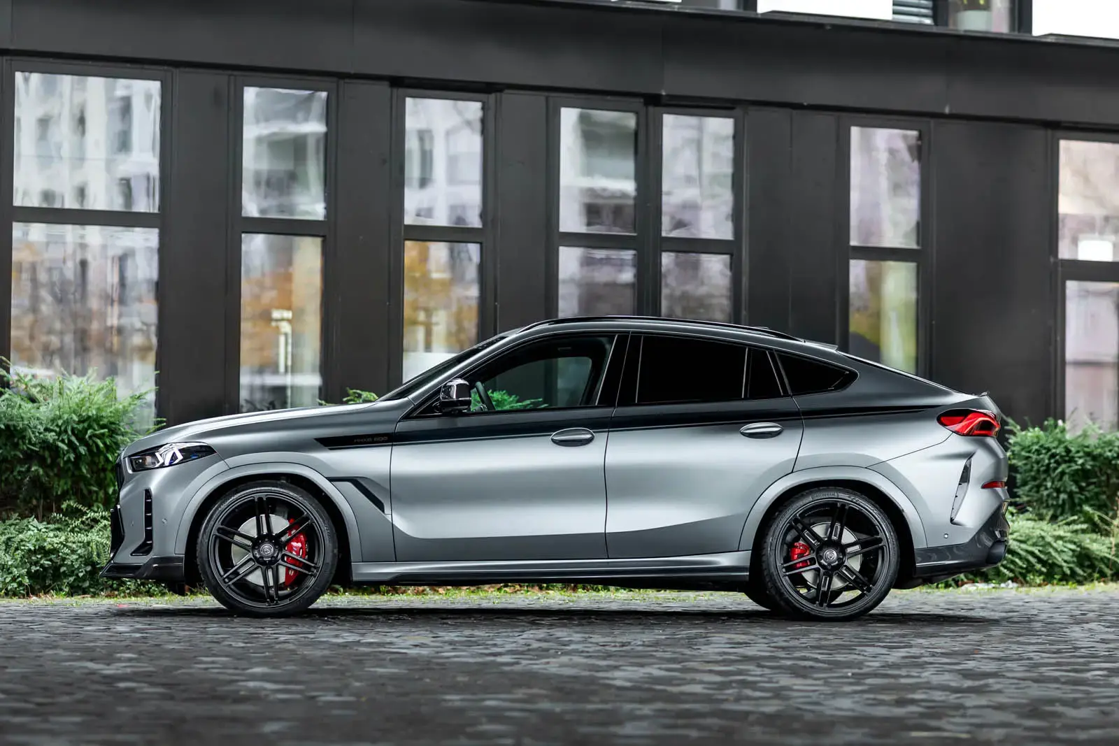 Manhart MHX6 500 BMW X6 side profile showing 22-inch Concave One wheels and lowered suspension