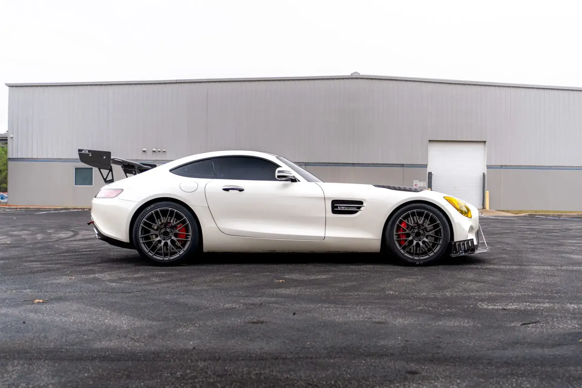 2016 Mercedes-AMG GT S rear three-quarter view in Designo Diamond White with APR carbon fiber rear wing and louvers