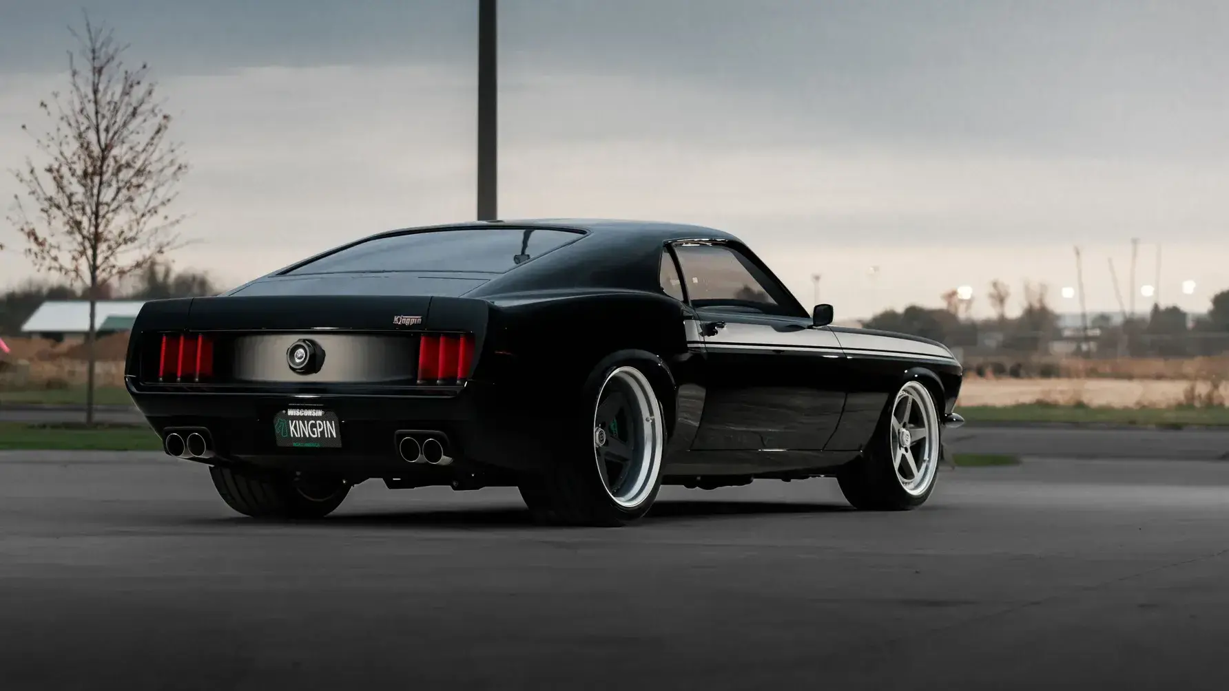 Ringbrothers KINGPIN 1969 Ford Mustang Mach 1 rear three-quarter view showing carbon fiber diffuser and custom exhaust system
