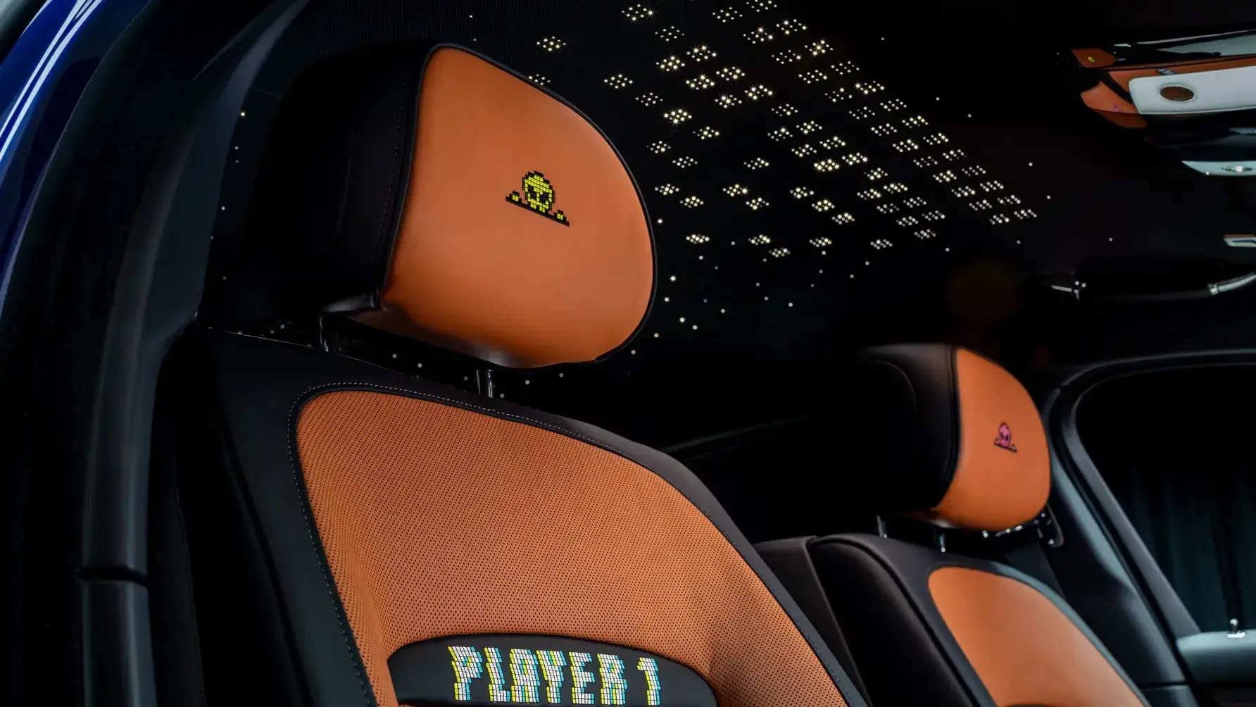 Rolls-Royce Black Badge Ghost Gamer interior showing embroidered player seats and custom starlight headliner with pixel motif