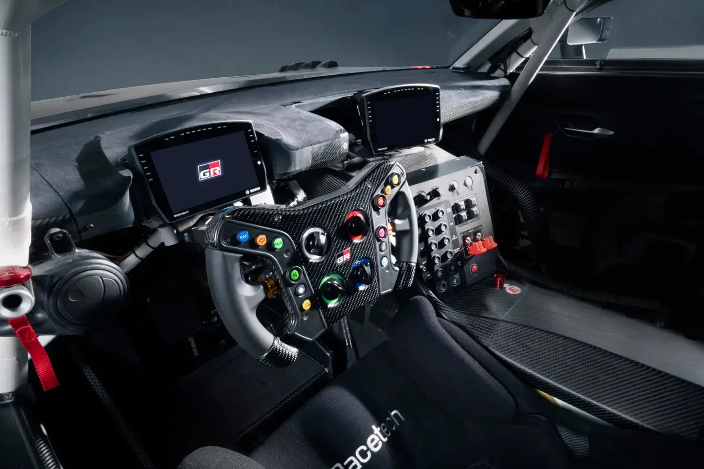 Toyota GR GT steering wheel close-up with carbon fiber trim, paddle shifters, and multifunction controls for the eight-speed automatic transmission