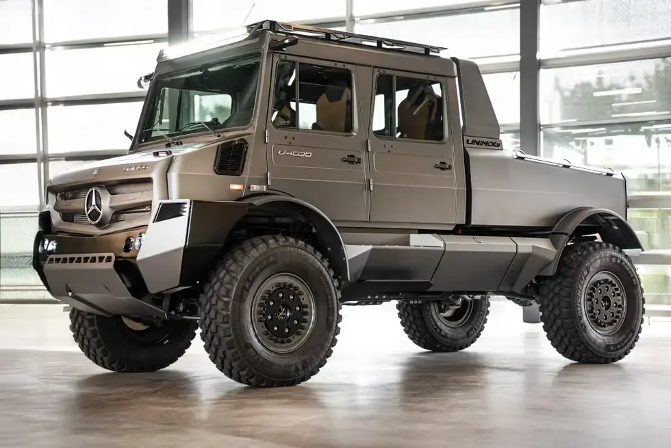 Mercedes-Benz Unimog side profile showing portal axles beadlock wheels and elevated ground clearance on rocky terrain